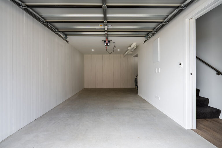 garage basement with adjacent staricase and unpainted AFS Rediwall panels for the basement walls.
